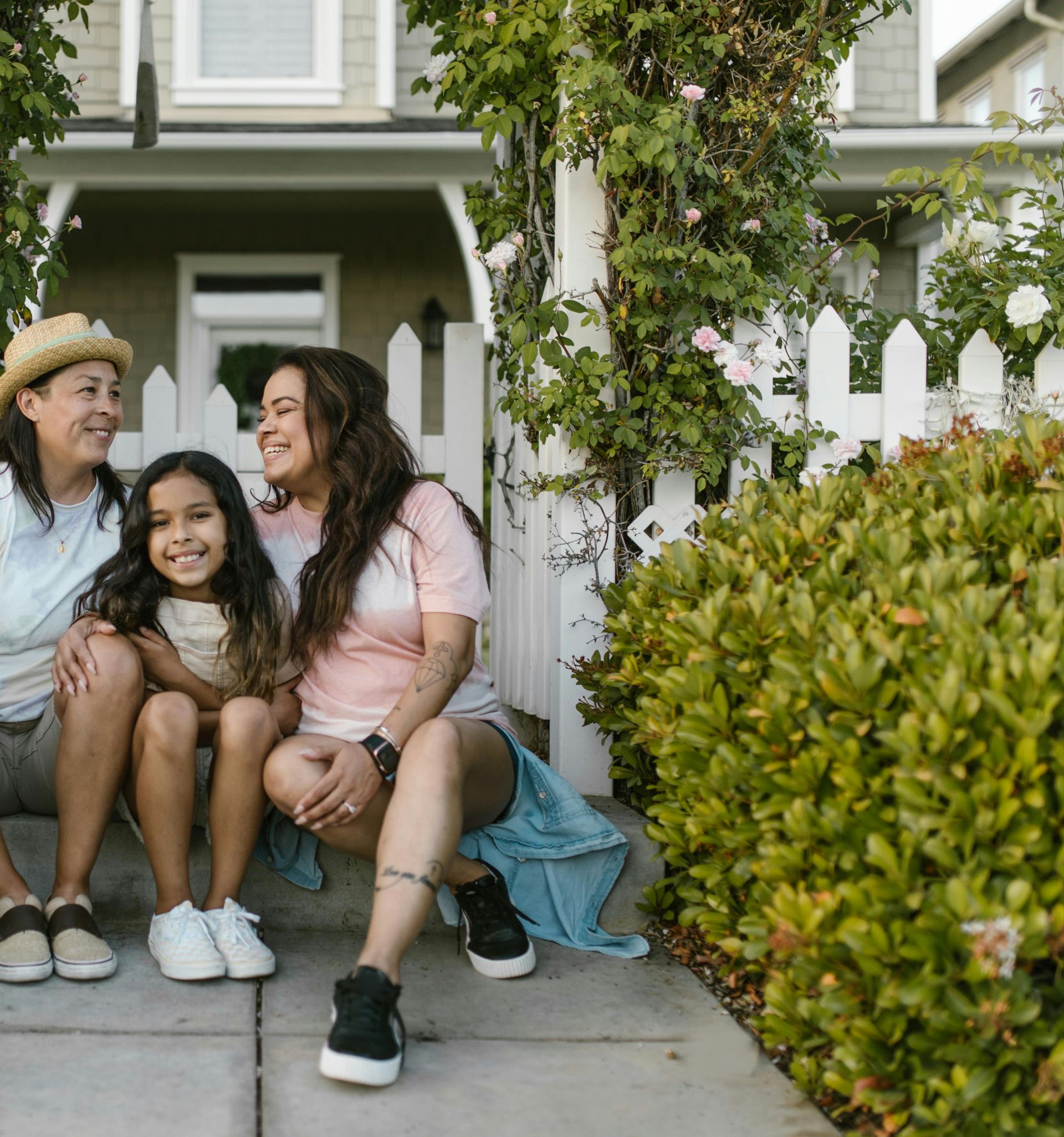 Happy Family Sitting Together in front of House