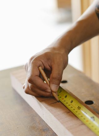 Crop craftsman measuring wooden plank